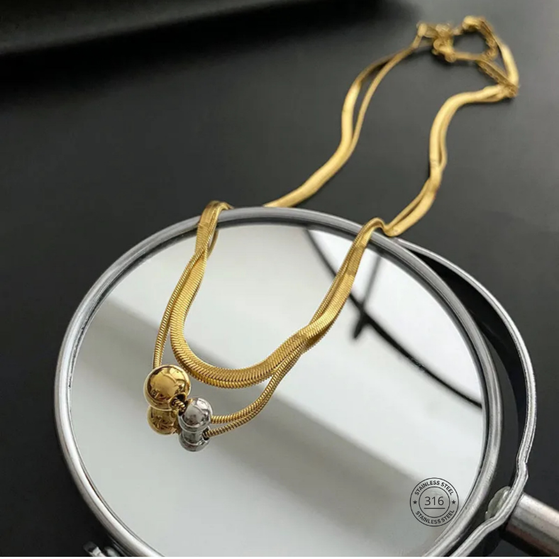 Collar doble con dijes circulares, color dorado. Acero inoxidable.